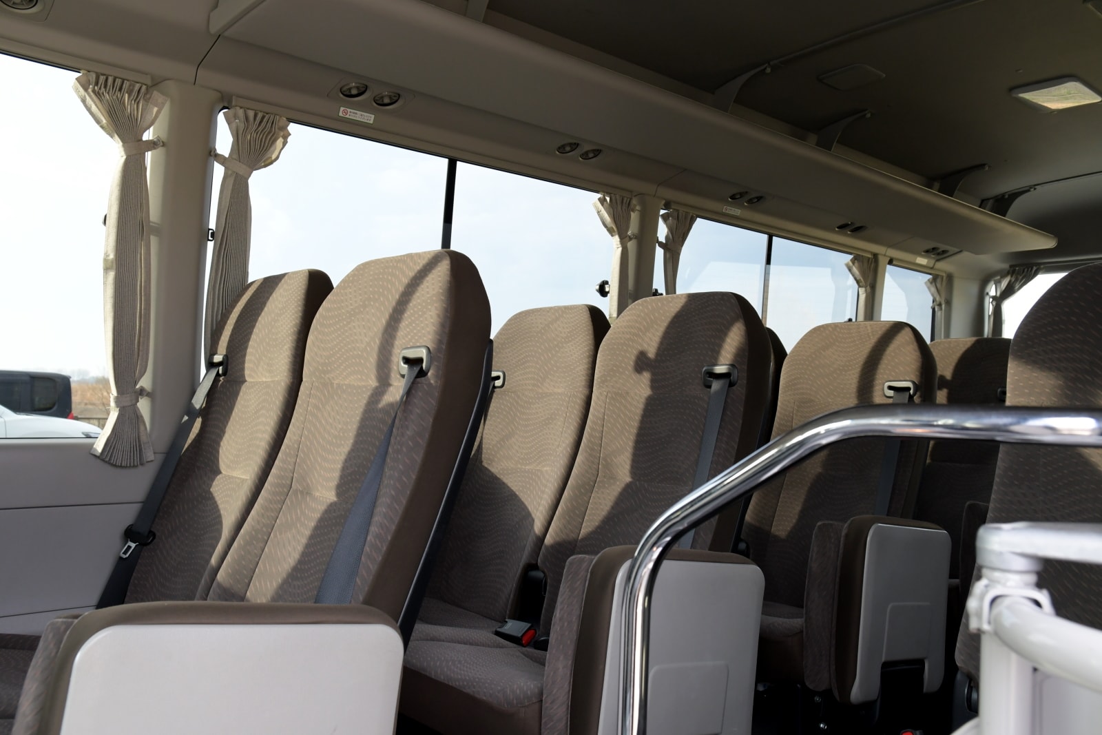 Reclining seats inside an AstraMove Toyota Coaster hired in Dhaka